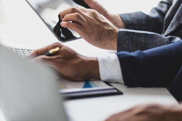 Businessmen discuss financial advisors analyzing data, charts and graphs of business financial growth and planning investment strategies. Businessmen discuss financial advisors analyzing data, charts and graphs of business financial growth and planning investment strategies.